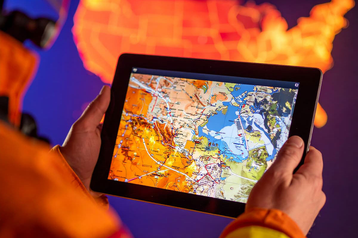 Firefighter monitoring real-time US wildfire data on tablet